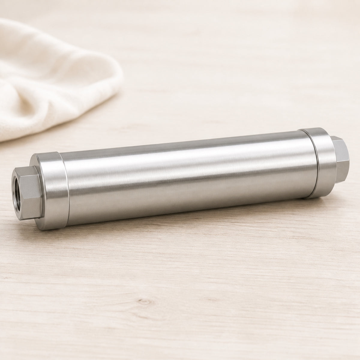 Anti-tartre galvanique cylindrique en inox brossé sur fond clair, raccord femelle visible